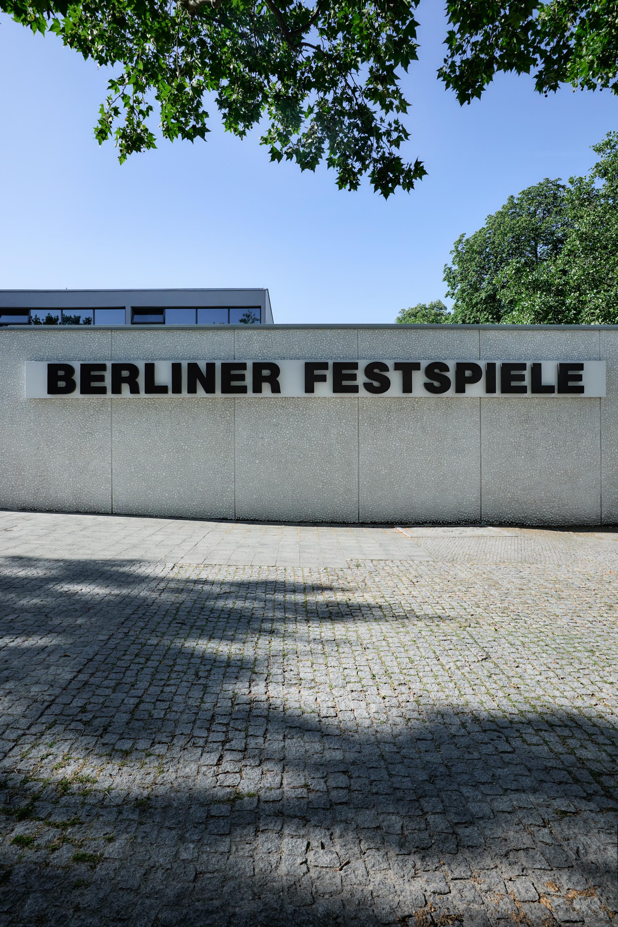Frontalansicht des Haus der Berliner Festspiele. Zu sehen ist die Kassenhalle. Auf der Fassade steht in schwarzen Lettern "Berliner Festspiele" geschrieben.