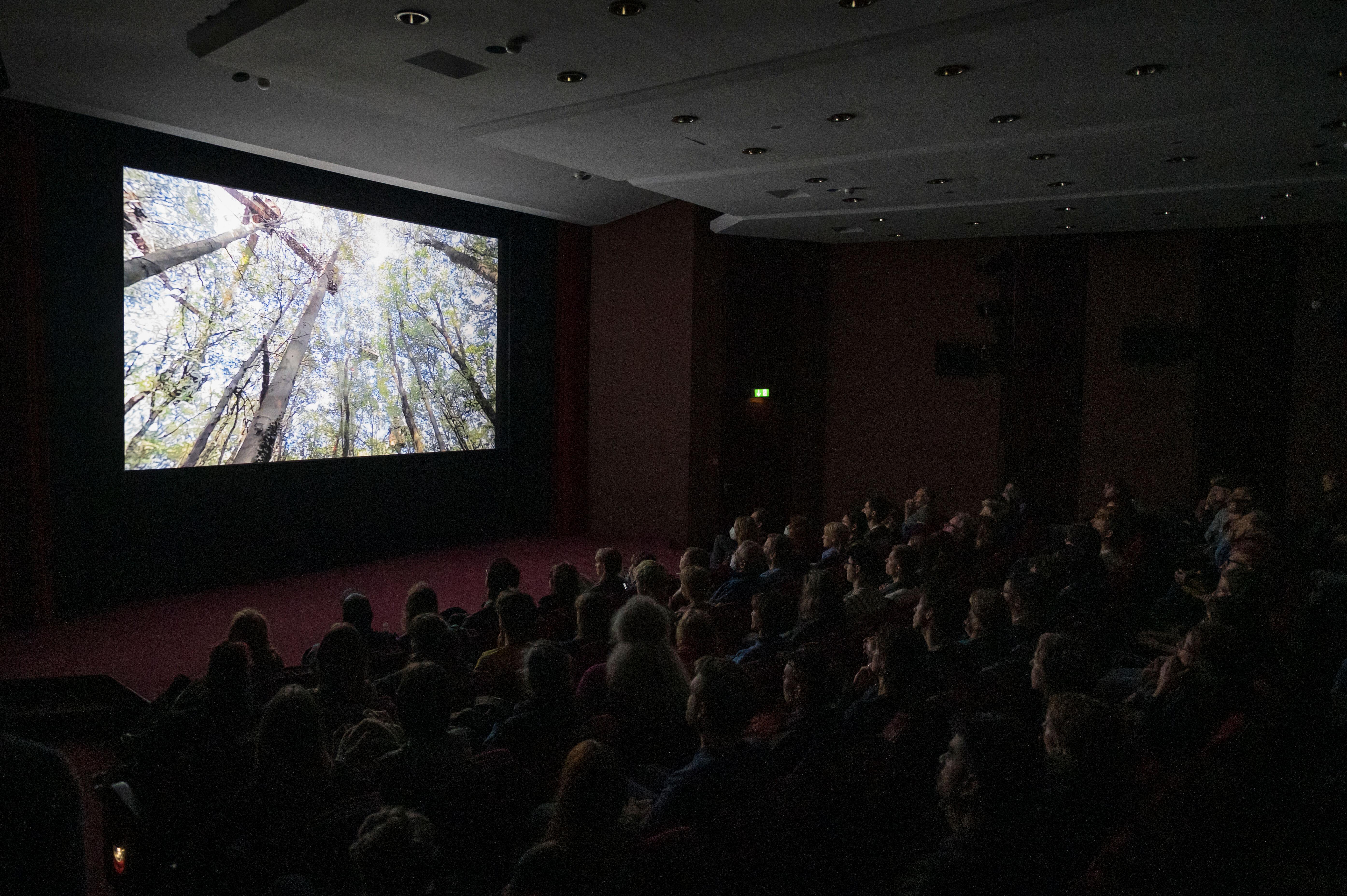 The cinema hall of the Zeiss-Großplanetarium with audience. On the big screen is the movie "Vergiss Meyn Nicht".