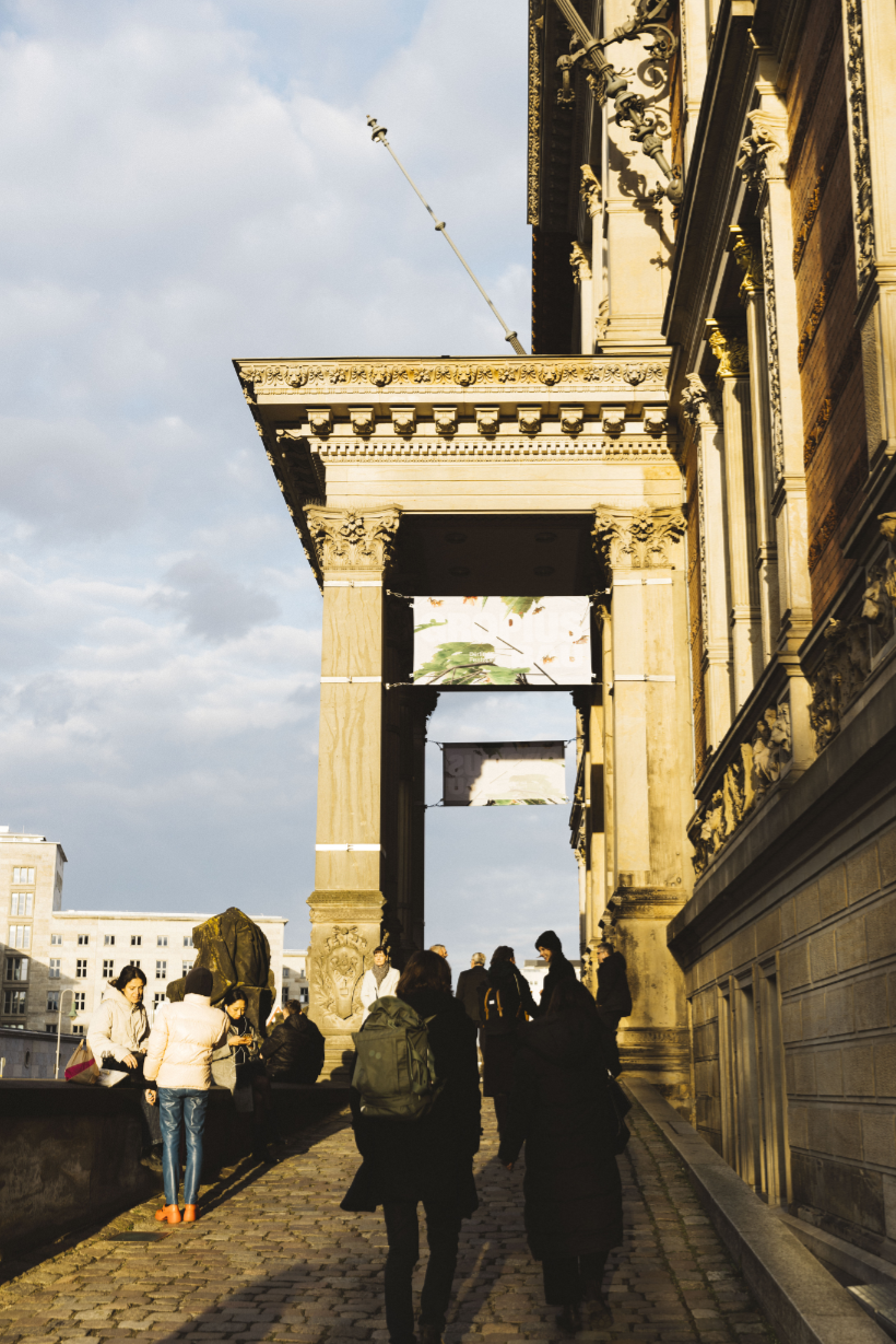 Exterior view of the Gropius Bau in the evening light. Visitors are standing at the entrance.