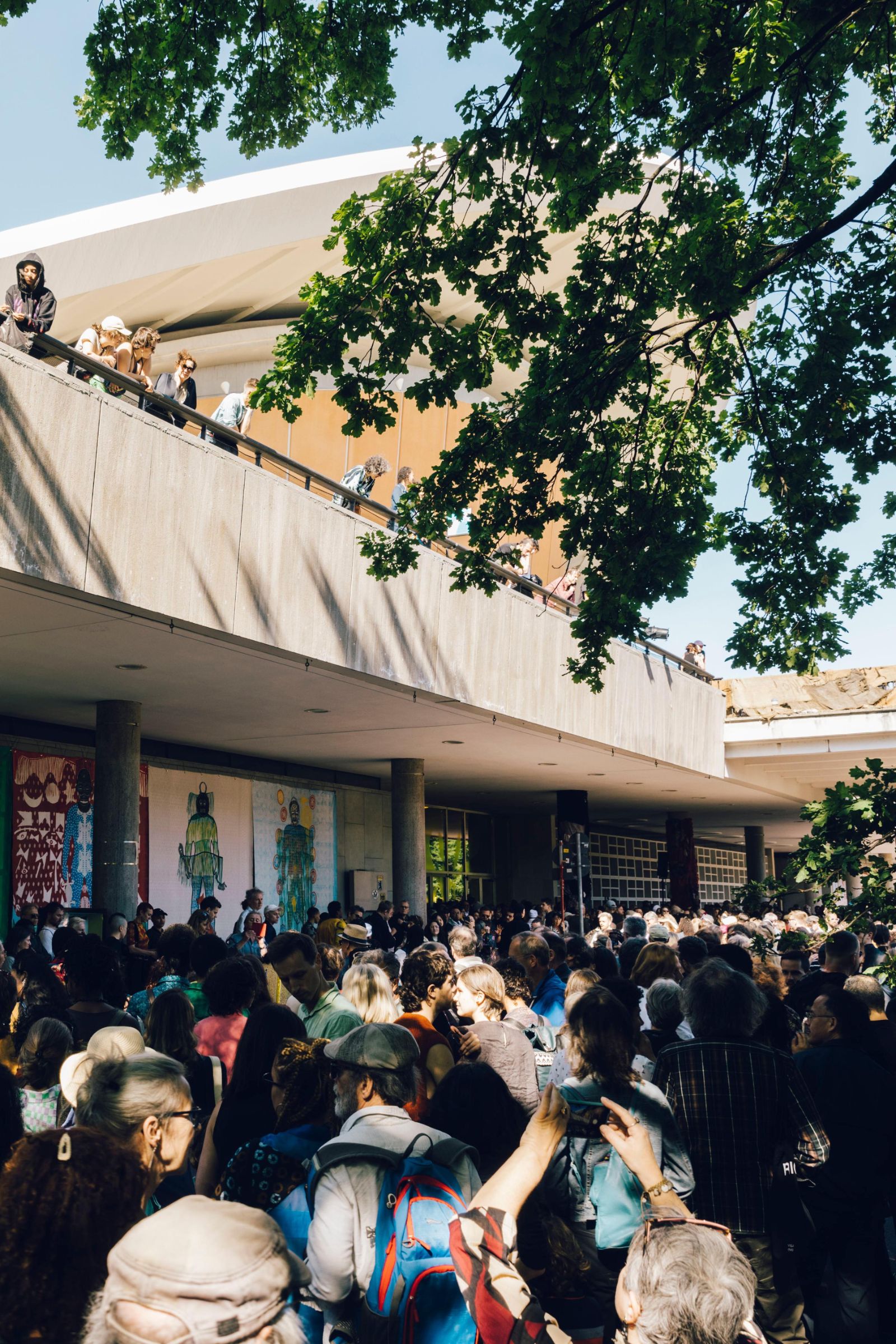 Personen stehen auf dem Vorplatz des Haus der Kulturen der Welt.